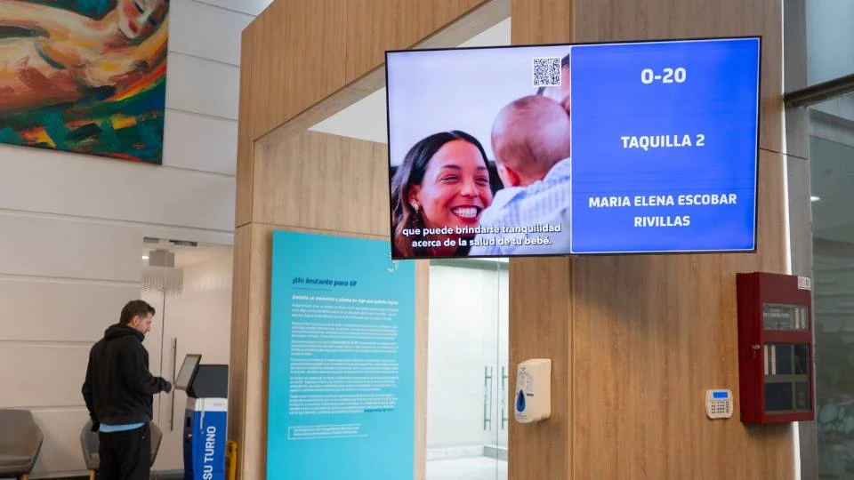 Monitor inteligente combinando cartelería digital para publicidad corporativa con el llamado visual de turnos en tiempo real